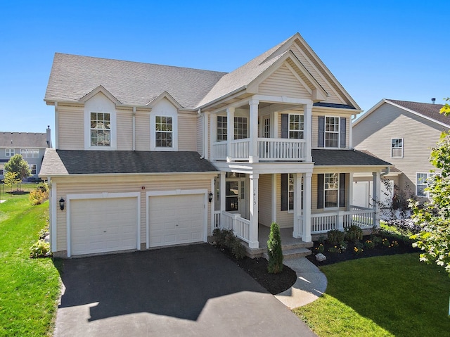 view of front of property featuring a porch, a front yard, and a garage