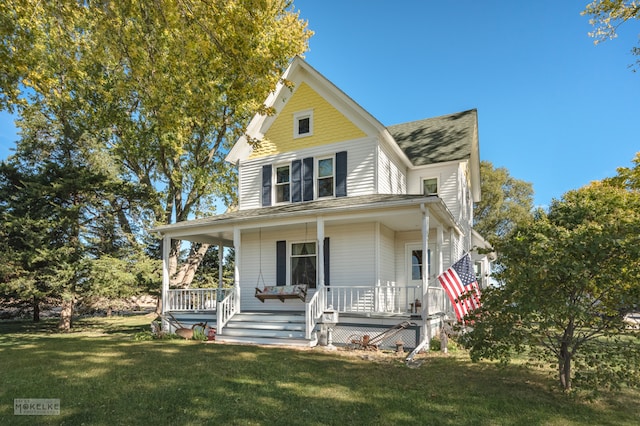 country-style home featuring covered porch and a front yard