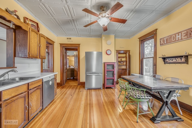 kitchen featuring ceiling fan, sink, light wood-type flooring, and appliances with stainless steel finishes