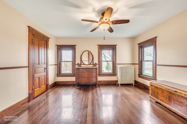 unfurnished room featuring radiator, hardwood / wood-style floors, and ceiling fan