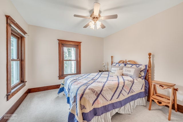 bedroom with ceiling fan, multiple windows, and light colored carpet