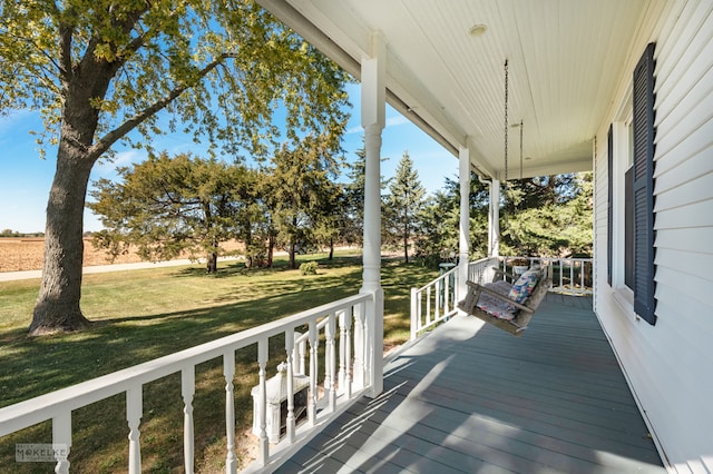 wooden terrace with covered porch and a yard