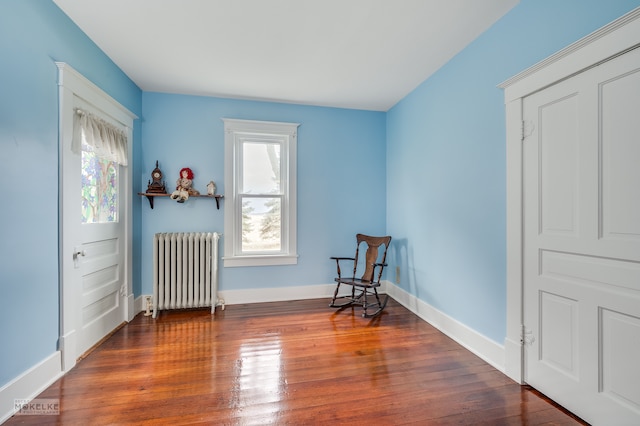 sitting room with plenty of natural light, dark hardwood / wood-style floors, and radiator