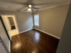 unfurnished room featuring dark hardwood / wood-style flooring, ornamental molding, and ceiling fan