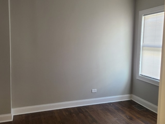 unfurnished room with dark wood-type flooring