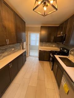 kitchen featuring dishwasher, sink, decorative backsplash, black range with electric stovetop, and dark brown cabinets