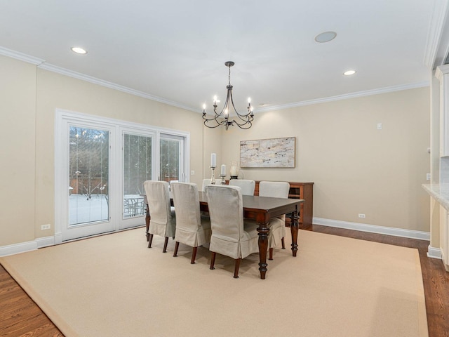 dining room featuring ornamental molding, wood-type flooring, and an inviting chandelier