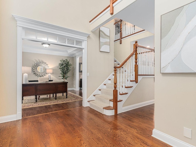 foyer entrance featuring crown molding and hardwood / wood-style floors