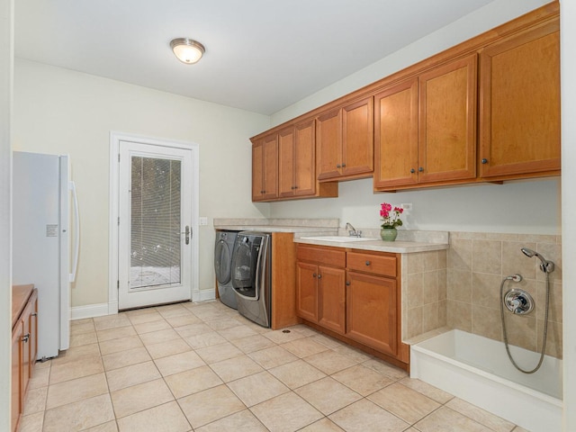 laundry room with light tile patterned flooring, separate washer and dryer, and sink