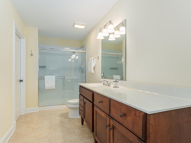 bathroom featuring tile patterned floors, vanity, toilet, and a shower with shower door