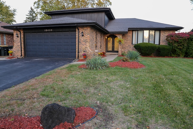 view of front of home featuring a garage and a front lawn