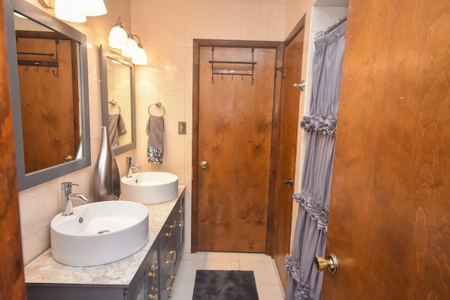 bathroom with tile walls, vanity, and tile patterned flooring