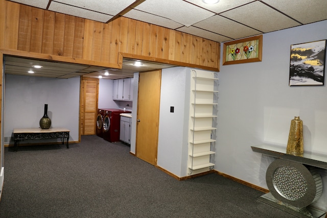 basement with washing machine and dryer, a paneled ceiling, and dark carpet