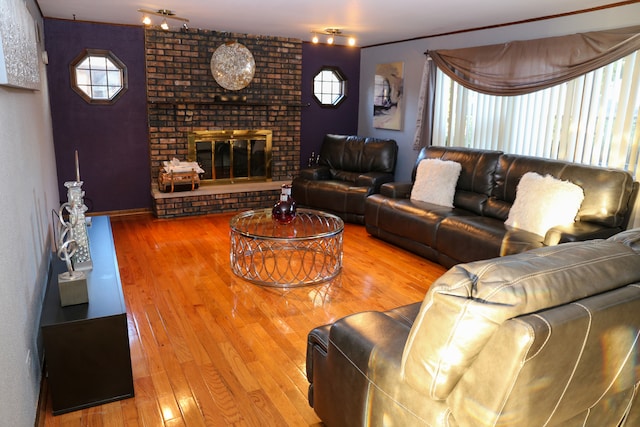 living room featuring wood-type flooring and a brick fireplace