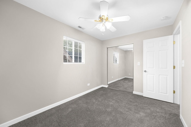 unfurnished bedroom with a closet, ceiling fan, and dark carpet