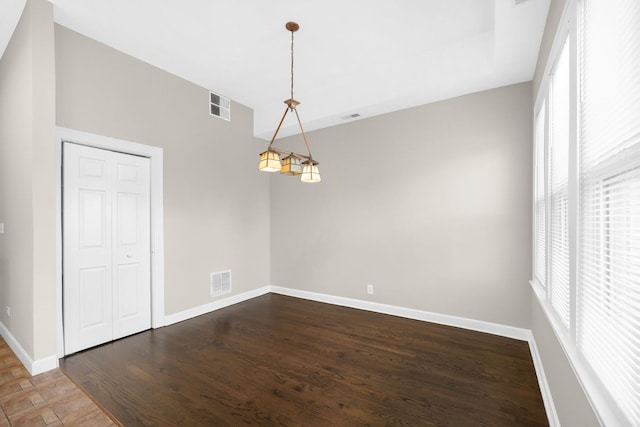 empty room with a wealth of natural light and wood-type flooring