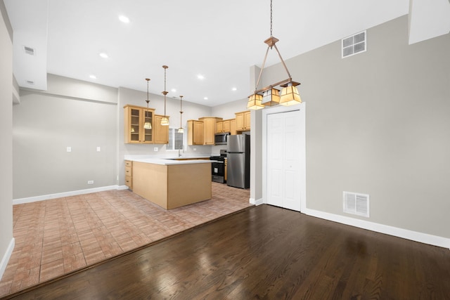 kitchen with appliances with stainless steel finishes, light hardwood / wood-style flooring, kitchen peninsula, and pendant lighting