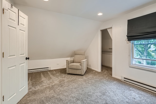 living area featuring vaulted ceiling, a baseboard heating unit, and carpet