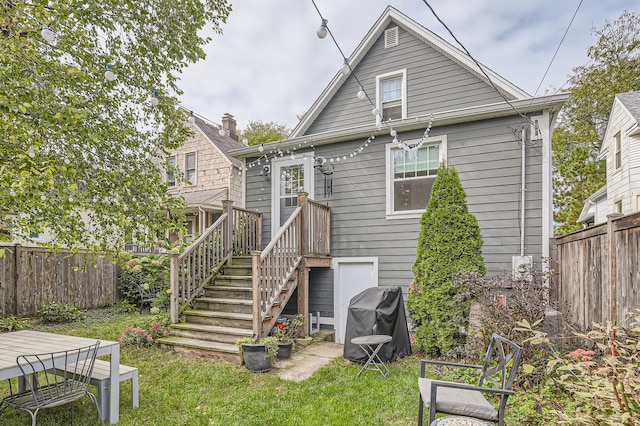 rear view of property with a yard