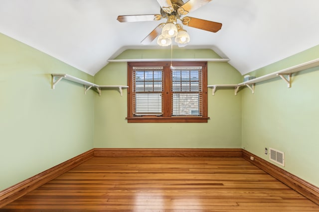 spacious closet with vaulted ceiling, hardwood / wood-style flooring, and ceiling fan