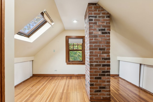 bonus room featuring light hardwood / wood-style floors and lofted ceiling with skylight