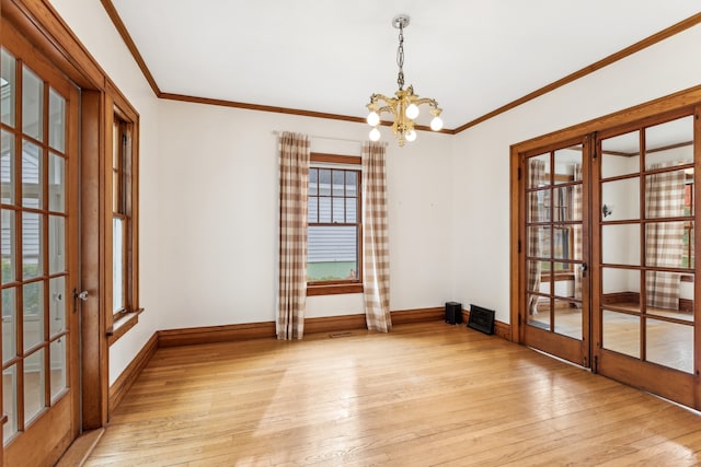 unfurnished room featuring light hardwood / wood-style floors, an inviting chandelier, and ornamental molding