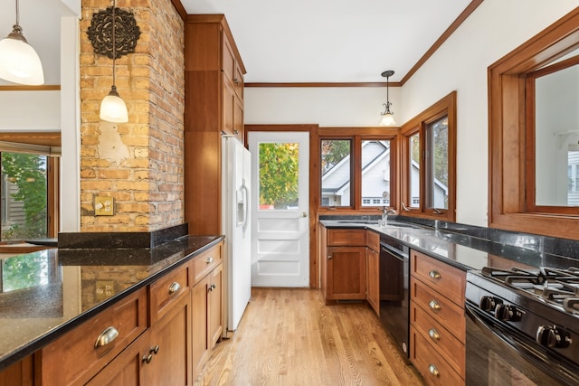 kitchen with hanging light fixtures, dark stone countertops, black appliances, crown molding, and light wood-type flooring