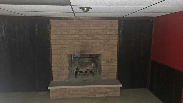 basement featuring a drop ceiling and a fireplace