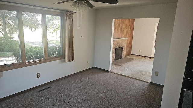 unfurnished living room with carpet, a fireplace, and ceiling fan