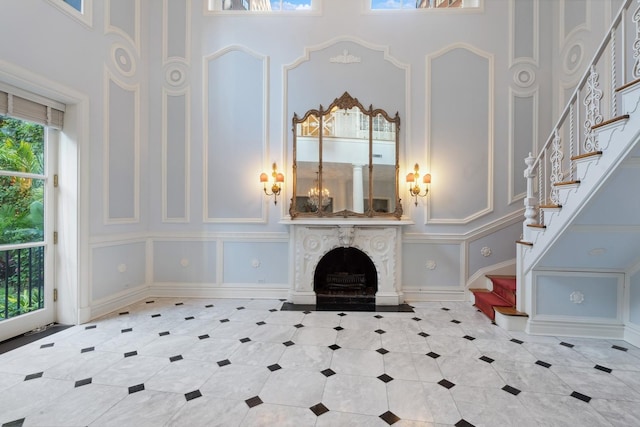 1355 N Astor St, Chicago, IL 60610 - unfurnished living room featuring a premium fireplace, tile patterned flooring, a decorative wall, stairway, and a high ceiling