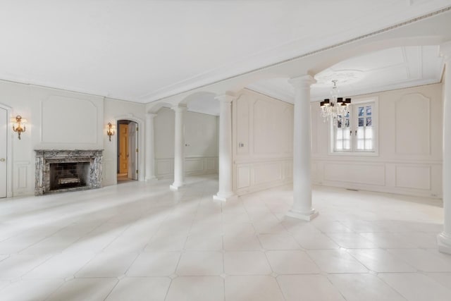 1355 N Astor St, Chicago, IL 60610 - unfurnished living room featuring decorative columns, a decorative wall, a fireplace, and a notable chandelier