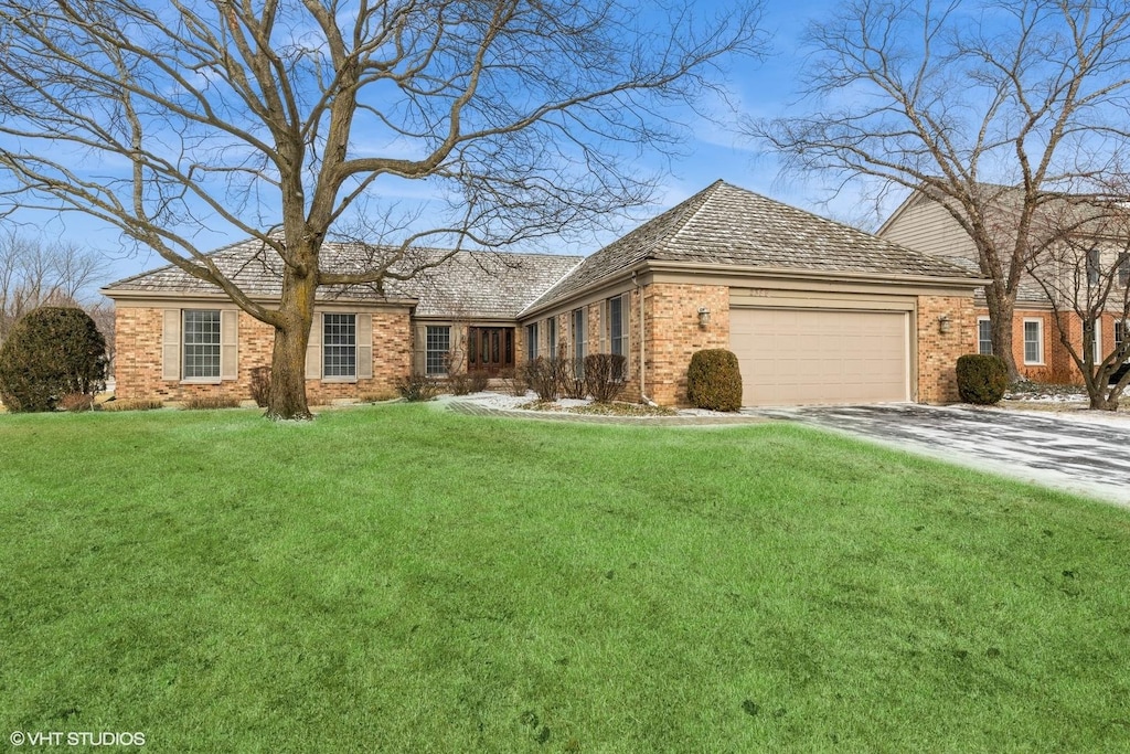 single story home featuring a garage and a front yard