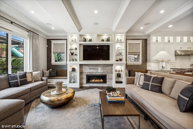 living room with ornamental molding and a high end fireplace