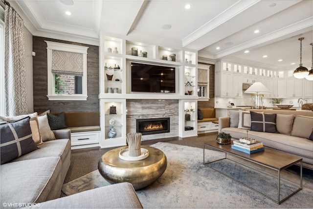 living room featuring a premium fireplace, sink, and ornamental molding