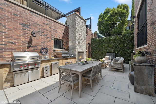 view of patio / terrace featuring exterior kitchen and a grill