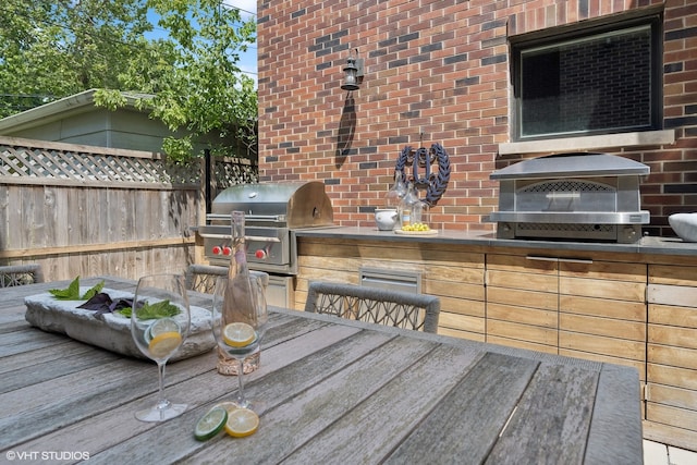 wooden terrace featuring area for grilling and exterior kitchen