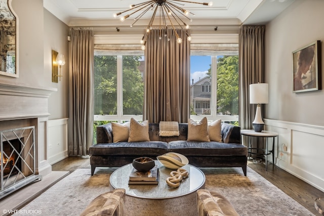 living room with hardwood / wood-style flooring, a healthy amount of sunlight, and ornamental molding