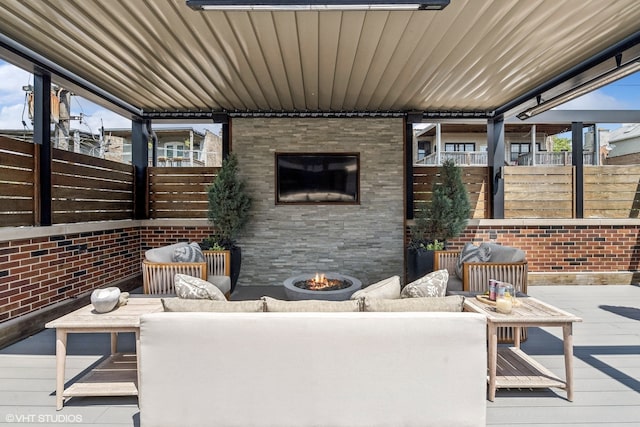 view of patio / terrace with an outdoor living space with a fireplace and a deck