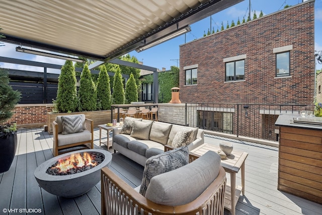 wooden terrace with an outdoor living space with a fire pit