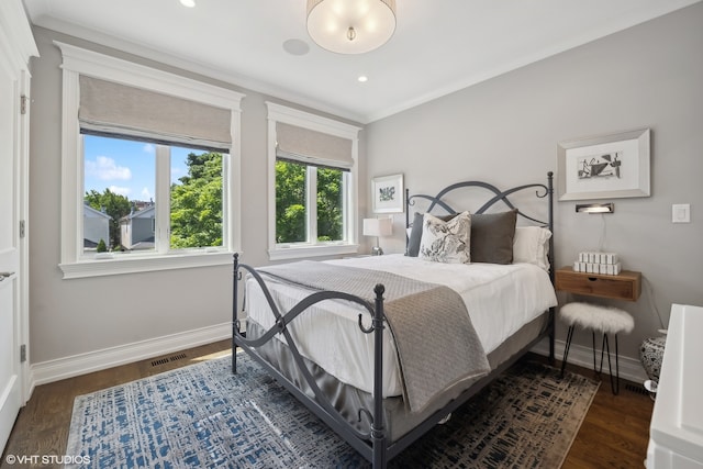 bedroom with ornamental molding and dark hardwood / wood-style flooring