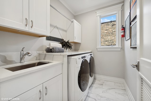 clothes washing area with sink, washer and dryer, ornamental molding, and cabinets