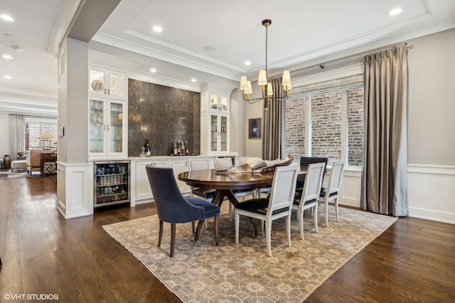 dining room featuring wine cooler, ornamental molding, a chandelier, and dark hardwood / wood-style flooring