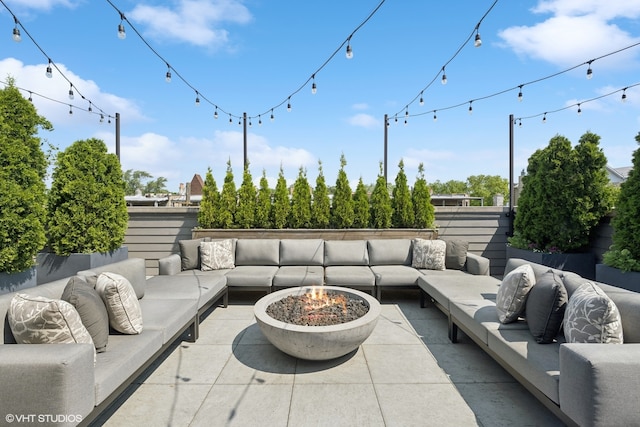 view of patio with an outdoor living space with a fire pit