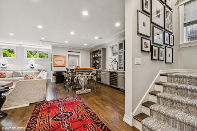 interior space with dark wood-type flooring, wine cooler, and ornamental molding