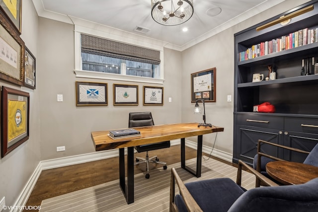 office with light hardwood / wood-style floors, a notable chandelier, and ornamental molding