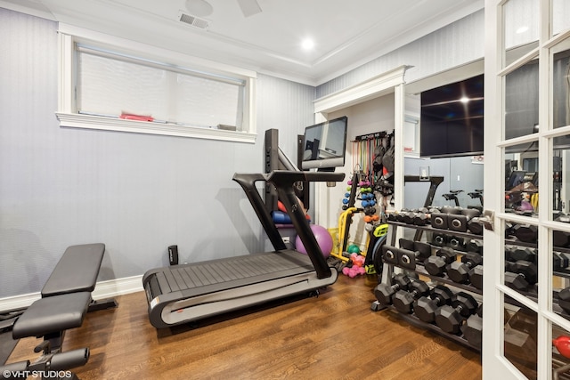 workout room featuring crown molding and hardwood / wood-style flooring