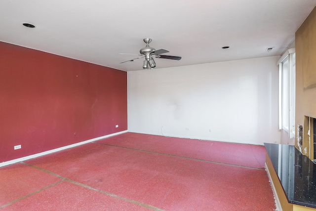 carpeted empty room with a ceiling fan, visible vents, and baseboards