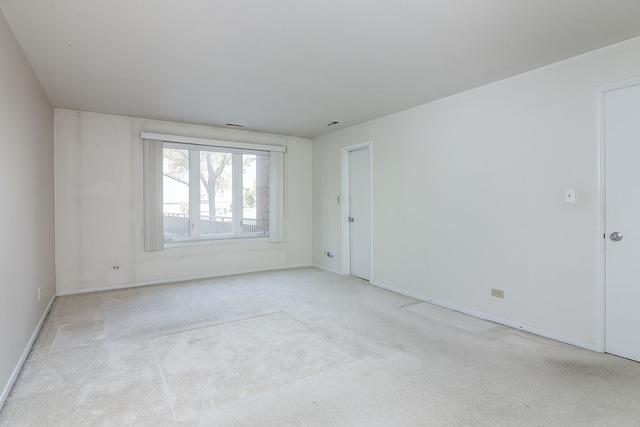 carpeted empty room featuring baseboards