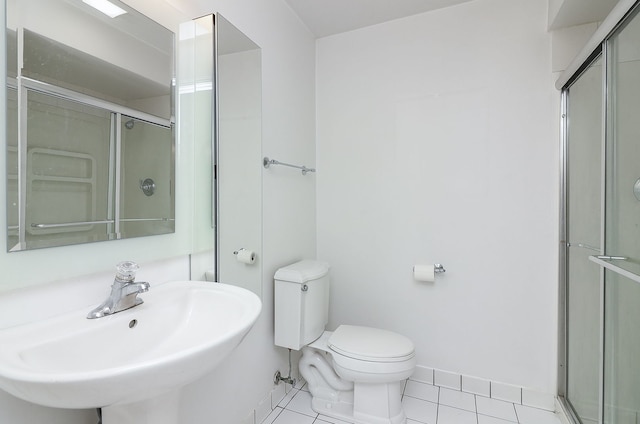 full bath featuring toilet, a shower stall, a sink, and tile patterned floors