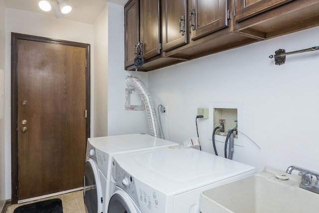 washroom featuring cabinet space, washer and dryer, and a sink